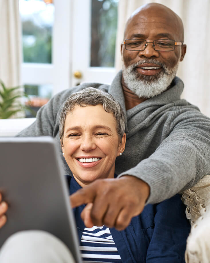 couple looking at a tablet computer while sitting on the couch together